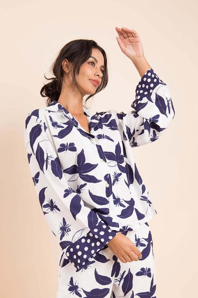 na foto, a modelo está com os braços flexionados mostrando a camisa do pijama longo helena, evidenciando o barrado de poá na manga