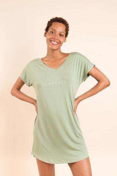na foto, a modelo está com as mãos na cintura e usando a camisola camisetão verde botânico com o silk aplicado 