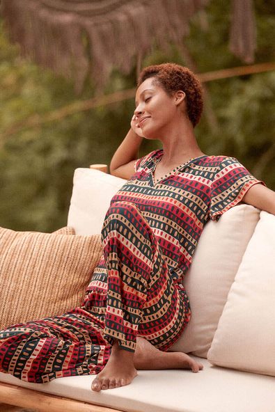 foto de campanha da modelo sentada num sofa usando o pijama longo de malha casca